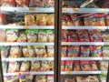 Packed chicken nugget in various brand placed in display chiller refrigerator inside the huge supermarket.