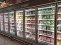 Packed chicken nugget in various brand placed in display chiller refrigerator inside the huge supermarket.