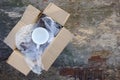 Packed cup in a plastic bubble wrap on an old wooden background. Fragile package