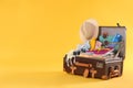 Packed vintage suitcase with different beach objects on background, space for text. Summer vacation
