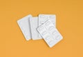 Packets of medication in a pile on an orange background, stack of blister packs Royalty Free Stock Photo
