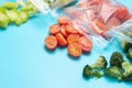 Packets of scattered and frozen vegetables on blue plate with copy space Royalty Free Stock Photo