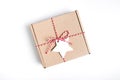 Packing Christmas gifts. Eco craft holidays gift box tied with red and white string , decorations on white Royalty Free Stock Photo