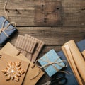 Packing Christmas gifts in vintage beige blue roll paper on old wooden desk. Top View. Flat Lay. Copy space. Royalty Free Stock Photo