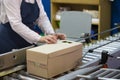 Packing conveyor. The hands of the packer pack