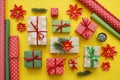 Packing a New Year`s gift. Yellow background. Many gift boxes tied with ribbons. Fir b Royalty Free Stock Photo