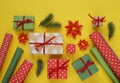 Packing a New Year`s gift. Yellow background. Many gift boxes tied with ribbons. Fir b Royalty Free Stock Photo