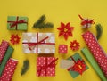 Packing a New Year`s gift. Yellow background. Many gift boxes tied with ribbons. Fir b Royalty Free Stock Photo