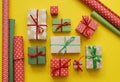 Packing a New Year`s gift. Yellow background. Many gift boxes tied with ribbons. Fir b Royalty Free Stock Photo