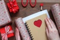 Packing a notebook with heart in gift paper to St. Valentine`s Day