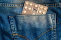 Packing pills in the back pocket of blue jeans Royalty Free Stock Photo