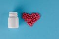 Packing pills. Heart shape made of pills. Pills spilling out of a jar on a blue background Royalty Free Stock Photo