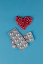 Packing pills. A scattering of red pills in the form of a heart on a blue background Royalty Free Stock Photo