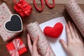 Packing a plush heart in gift paper by St. Valentine`s Day