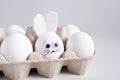 Packing white eggs in a cardboard box. One egg in the form of an Easter bunny Royalty Free Stock Photo