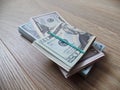 Packs of real dollar banknotes on a wooden table. Thousands dollars of cash.