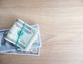 Packs of real dollar banknotes on a wooden table. Thousands dollars of cash. With free space for a text.