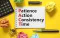PACT patience action consistency time symbol. Concept words PACT patience action consistency time on white note, yellow background