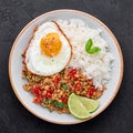 Pad Krapow Gai - Thai Basil Chicken with Rice and fried Egg black slate background. Pad Krapow is Thai cuisine dish