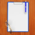 Pad with paper, glasses and pen on the table Royalty Free Stock Photo