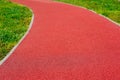 padded rubber sport and running track floor in selective focus. green grass on the sides.