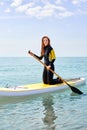 Paddle board fit redhead woman standing paddling away on stand up paddleboarding at sea Royalty Free Stock Photo