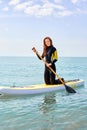 Paddle board fit redhead woman standing paddling away on stand up paddleboarding at sea