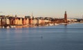 Paddle boarder on the central Stockholm river at sunset, preceding the city& x27;s colourful buildings, Kungsholmen Royalty Free Stock Photo