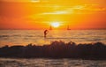 Paddle boarding during a beautiful sunrise. Panoramic view of sunset over ocean. Beautiful serene scene. Sea sky concept