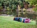 Paddle boats of all colors Lined Up Along a Lake with Fall Foliage reflecting in the water in Tomlinson Run State Park in West