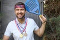 Paddle player holding a bunch of medals