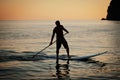 Paddle standing, silhouette of man on the beach at sunset Royalty Free Stock Photo