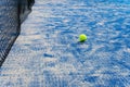 Paddle tennis ball on the court with the net on the background