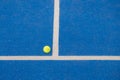 paddle tennis ball next to the baseline of a blue paddle tennis court Royalty Free Stock Photo