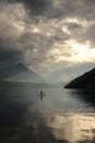 Paddleboarder on a mountian lake after storm Royalty Free Stock Photo