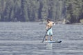 Paddleboarder paddles on a calm lake