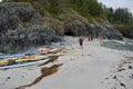 Paddlers explore a beach with sea caves, kayaks on shore in foreground