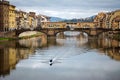 paddling on the Arno river in Florence with medieval stone bridge Ponte Vecchio on background. Tuscany, Italy