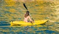 Paddling a kanu kayak in golden sunset ocean waters Royalty Free Stock Photo