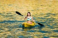 Paddling a kanu kayak in golden sunset ocean waters Royalty Free Stock Photo