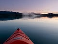 Paddling in a kayak through calm sunset waters Royalty Free Stock Photo