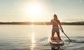 Paddling out to venture on. an attractive young woman paddle boarding on a lake. Royalty Free Stock Photo