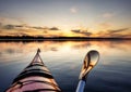 Paddling on red kayak towards sunset, absolutely calm water in Stocksjo Lake, close to Umea City, Vasterbotten County, Northern