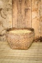 paddy rice in bamboo basket on mat weave and wood board background Royalty Free Stock Photo
