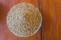 Paddy or unhusked rice in plate on top view close up with wooden