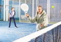 Padel game - teen girl actively kicks ball during a padel game