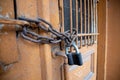 Padlock and chain on a wooden door with bars