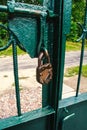 Locked old, antique padlock on the green gate. Royalty Free Stock Photo