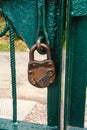 Locked old, antique padlock on the green gate. Royalty Free Stock Photo