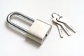 A padlock with elongated hook latch bar and three keys against a white backdrop Royalty Free Stock Photo